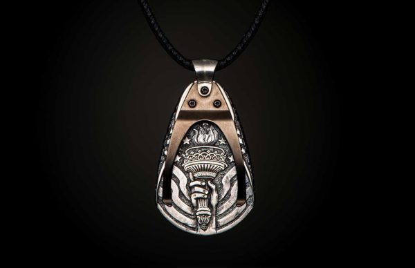 William Henry is proud of our American heritage, and we pay homage to the strength and ideals that created the dream we all share. The Denali is a striking pendant wrought in sterling silver with artwork that captures the iconography of our history. A wishbone clip in PVD black coated stainless steel holds one to three guitar picks, and whether you play guitar or you don’t, this piece is gorgeous on the neck. Finished with a fine stitched leather cord and sterling silver clasp, entirely built in our Oregon studio. - Image 3