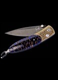 Chad Nichols 2.63 Hand Forged "Boomerang" Damascus 
SCALE: Blue Spruce
FRAME: KOFTAGARI
014/100

The Monarch 'Golden Scale' features a mesmerizing frame in 24K gold Koftgari (the ancient Indian technique of inlaying gold in tool-steel), inlaid with Norway Blue Spruce pine cone. The blade is 'Boomerang' damascus steel hand forged by Chad Nichols. The one-hand button lock and the thumb stud are set with white topaz gemstones.