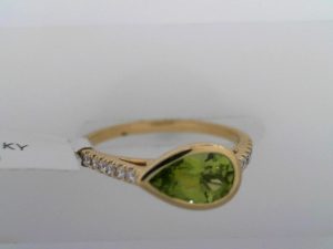 Lady's Yellow 18 Karat  East to West Bezel Set Pear Shape With Diamond Accents Fashion Ring Size 6.5 one = 0.86ct Pear Yellowish Green  Moderately Strong Peridot
12 = 0.11tw Round Diamonds