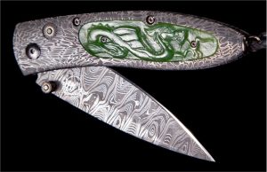 The Monarch 'Artemis' features a beautiful frame in hand-forged 'River Rock' damascus by Chad Nichols, inlaid with carved green jade scales. The blade is hand-forged 'Hornets Nest' damascus by Mike Norris. The one-hand button lock and the thumb stud are set with spinel gemstones.
The Monarch is a simple design that is easy on the eye and effortless in the hand. The 'Artemis' features some of William Henry's signature forged metals, and represents the perfect synthesis between elegance, function, modern and exotic materials; a distinctive personality statement to be worn and used for a lifetime.
Features & Specs
One-hand button lock system
Leather carrying case
Shipped in an elegant wood presentation box
Dimensions: 
Blade 2.63" (66.8mm)
Handle 3.58" (90.9mm)
Overall open 6.00" (152.4mm)
32 of 50