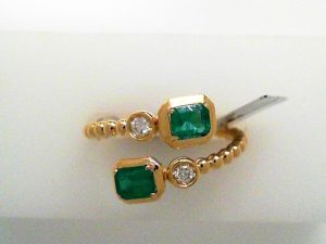 Lady's Yellow 14 Karat Contemporary By-Pass l set Fashion Ring prong set 2 = 0.64tw Emerald Green Emeralds
bezel set 2 = 0.08tw Round SI1 Diamonds with bead accent shank
sz 7