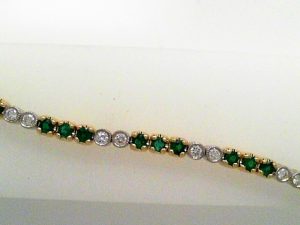 Lady's Two-Tone Yellow/White Gold 14 Karat Tennis Bracelet Bracelet  prong set 35 = 1.84tw Round Green Emeralds
 bezel set 24 = 0.73tw Round G/H SI1 Diamonds
with securty lock