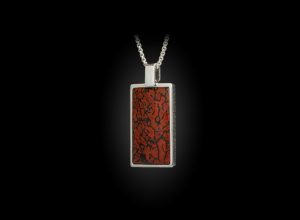 DINO SHIFT
This mini dog tag showcases Fossil Dinosaur bone (100 million years old)
 inlaid into Sterling Silver, with a satin finished engraving panel on the reverse side.
 Offered on a 22" Sterling Silver chain.
MATERIALS & ARTISTRY
Fossil Dinosaurbone
Sterling Silver
FEATURES & SPECS
Pendant is .9" tall x .56" wide x .14" thick