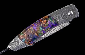 The Spearpoint 'Big Easy' features a beautiful frame in 'River Rock' damascus by Chad Nichols, inlaid with mini pine cones in resin. The blade is 'Wave' pattern damascus steel with an extra-strong core of ZDP-189. The one-hand button lock and the thumb stud are set with smoky quartz gemstones. A remarkable design that gives you an instrument with a full-size secure grip, and a versatile deep-belly blade, the Spearpoint epitomizes William Henry’s core philosophy – that superlative function deserves to be elevated to superlative art. The 'Big Easy' also features William Henry's most admired and distinctive forged metals; a timeless heirloom to be proudly worn and used for a lifetime before being handed-down to another generation
FEATURES & SPECS
One-hand button lock system

Dimensions:

Blade 3.06" (77.7mm)
Handle 4.13" (104.9.5mm)
Overall open 7.19" (182.6mm)