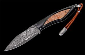 At William Henry, we love exotic woods. They are gorgeous, dynamic, unpredictable, and inspiring. The Burl features our resin-stabilized American maple burl, with bold pattern and nuanced chatoyance that captivates the eye. The burl is inset and framed bya black G10 composite handle, tough and comfortable. Fully polished by hand, assembled and dissembled multiple times, this architecture has an open channel to see thru to the damascus tang. The blade/tang are forged from 67 layers of three alloys, with a core of VG-10 at HRC 60 for optimal sharpness and wear resistance. Finished with a leather lanyard, sterling silver accents, and includes a sturdy brown leather sheath.
FEATURES & SPECS
Blade: 3"
Overall Length: 6 7/8"