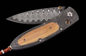 The Monarch 'Pappy II' features a beautiful frame in hand-forged 'Twist' damascus by Chad Nichols, inlaid with barrel wood from Pappy Van Winkle Bourbon. The blade is 'Wave' damascus with a VG-10 core; the one-hand button lock and the thumb stud are set with smoky quartz gemstones. The Monarch is a simple design that is easy on the eye and effortless in the hand; the elegant shape of the handle on this design is also an ideal canvas to showcase fine hand-engraving or exotic materials. The ‘Pappy II’ features some of the exotic materials, and hand-forged metals that are the hallmark of William Henry's collections; a timeless heirloom to be proudly worn and used for a lifetime before handing it down to another generation.

FEATURES & SPECS
One-hand button lock system
Leather carrying case
Shipped in an elegant wood presentation box

Dimensions:

Blade 2.63" (66.8mm)
Handle 3.58" (90.9mm)
Overall open 6.00" (152.4mm)