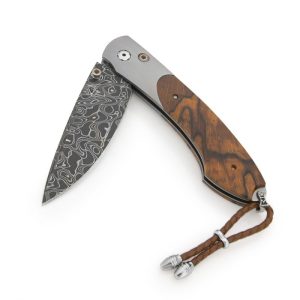 The Spearpoint ‘Forest Grove’ features a light and resilient frame in aerospace grade titanium, inlaid with a beautiful piece of orange spalted beech wood. The blade hand-forged 'Intrepid' damascus steel by Chad Nichols. The one-hand button lock and the thumb stud are set with citrine gemstones. A remarkable design that gives you an instrument with a full-size secure grip, and a versatile deep-belly blade, the Spearpoint epitomizes William Henry’s core philosophy – that superlative function deserves to be elevated to superlative art. The ‘Forest Grove’ features some of the exotic materials and hand-forged metals that are the hallmark of William Henry's collections; a distinctive personality statement to be worn and used for a lifetime.
Product SKU: B12 FOREST GROVE

MATERIALS
Hand-forged damascus
Titanium
Beech Wood