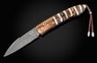 Features & Specs
One-hand automatic button lock system
Leather carrying case
Shipped in an elegant wood presentation box
Dimensions:
Blade 3.3" (83.8mm)
Handle 4.0" (101.6mm)
Overall open 7.3" (177.8mm)
The Bolt 'Mammut' automatic opener featuresa frame in heat-colored 'Wave' mokume, inlaid with a beautiful piece of 10,000 year-old fossil Woolly Mammoth tooth. The blade is hand-forged 'Meadows' damascus steel by Chad Nichols. The one-hand button lock is set with a smoky quartz gemstone.
The Bolt 'Mammut' delivers a fresh take on our signature pocketknives, combining a swift automatic opening blade with a secure grip for effortless daily use. True to William Henry’s philosophy, 'where superlative function meets superlative art', this model’s action has been refined to perfection, elevating your experience to a new level. Every knife is meticulously fashioned from exotic materials and hand-forged metals, and each detail reflects our commitment to timeless design and impeccable performance, making the Bolt worthy of appreciation for a lifetime.
Product SKU: B22 MAMMUT